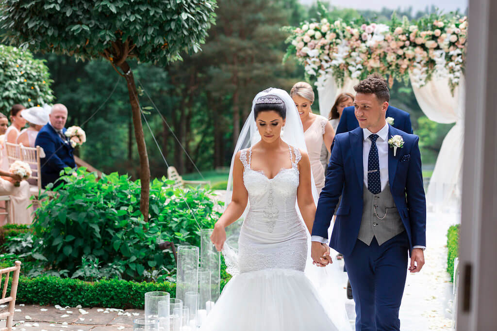 A candid shot of the bride and groom walking down the aisle hand in hand.