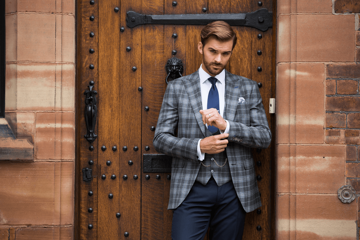 Model fixing the cuff on his patterned suit jacket.