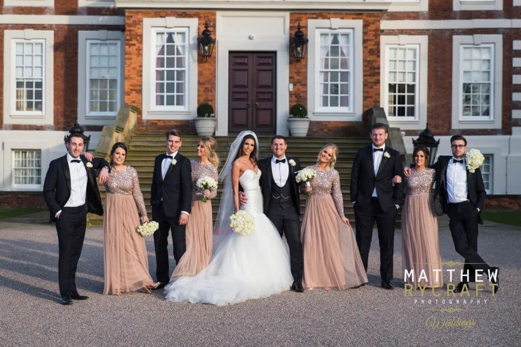 The bride and groom pose with their bridesmaids and groomsmen. 