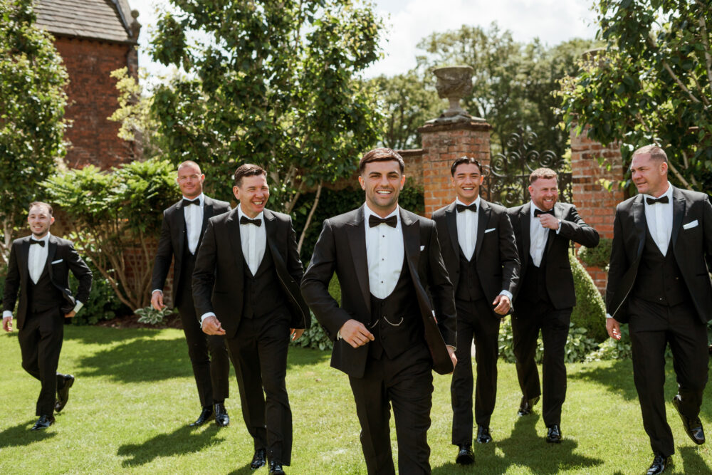 Bespoke black dinner suit in light weight, 100% wool. 3 piece bespoke dinner suit with bespoke black tuxedo jacket, bespoke black dinner suit trousers and bespoke black horseshoe waistcoat. Features a slim fit 1 button black dinner jacket with jetted pockets and black satin peak lapel. Worn with bespoke white studded dress shirt with French cuff shirt and large tom ford style bow tie and white pocket square.