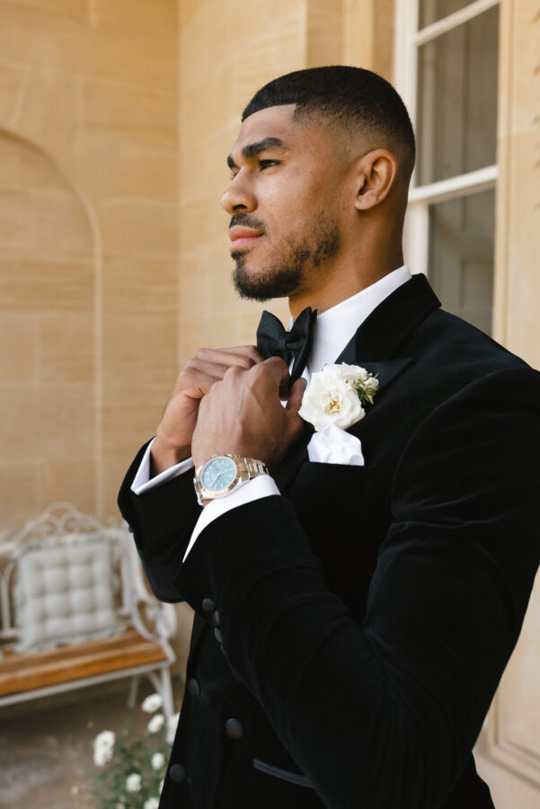 Bespoke black velvet Double breasted dinner suit. Dinner suit with double breasted black velvet tuxedo jacket and classic black dinner suit trousers. Features a 6 button black double breasted dinner jacket with classic black satin peak lapel. Worn with white studded dress shirt with French cuff shirt and large tom ford style bow tie and white pocket square.
