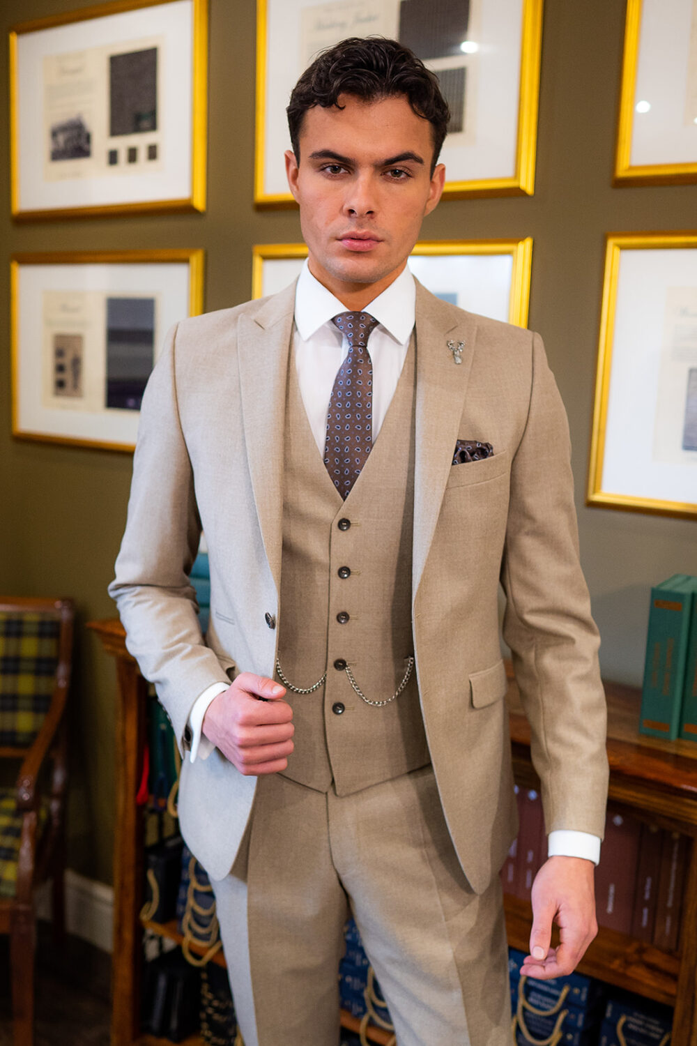 Slim fit beige suit in light weight, 100% wool. 3 piece beige suit with matching beige jacket, beige single breasted waistcoat and beige trousers. Features a slim fit 2 button jacket with classic notch lapel. Worn with white French cuff shirt and coordinating tonal brown silk tie and pocket square