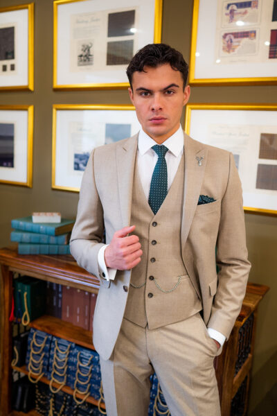Slim fit green custom suit in light weight, 100% wool. 3 piece green custom suit with matching green jacket, green single breasted waistcoat and green trousers. Features a slim fit 2 button jacket with classic notch lapel. Worn with white French cuff shirt and green and white spot silk tie and pocket square.